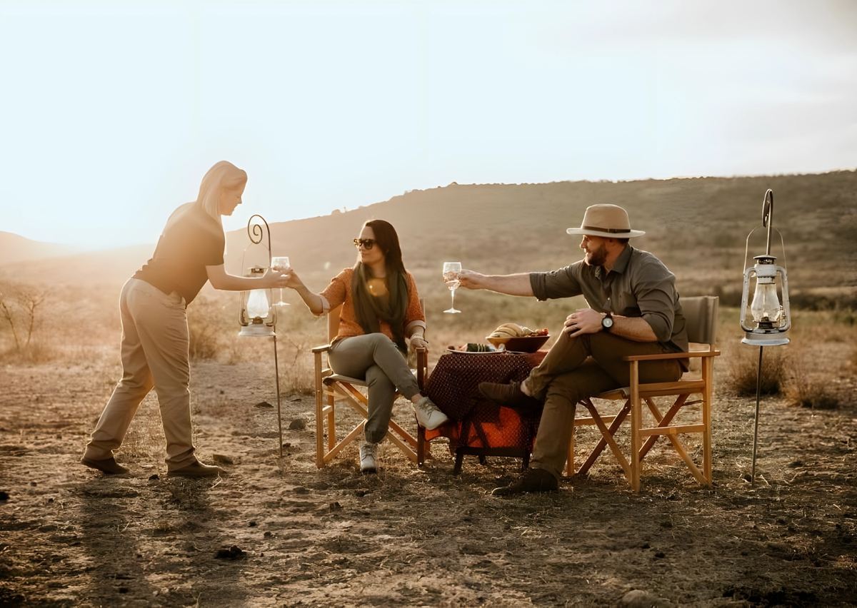 Sundowners poured in the bush, with lanterns and a small table