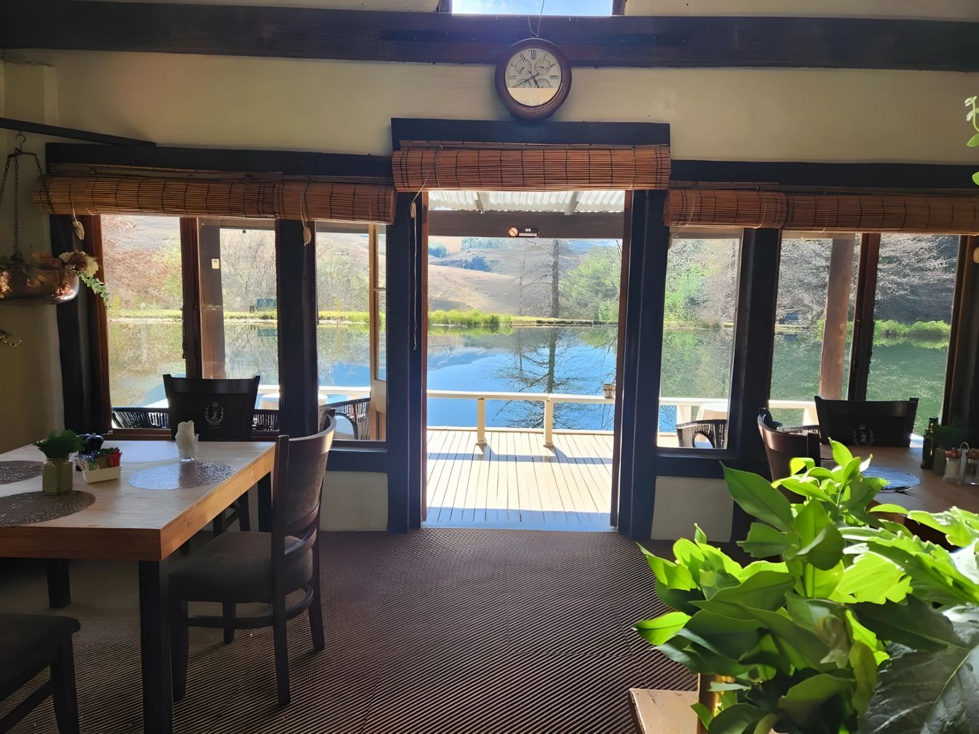 The dining room with doors open onto the deck and the dam