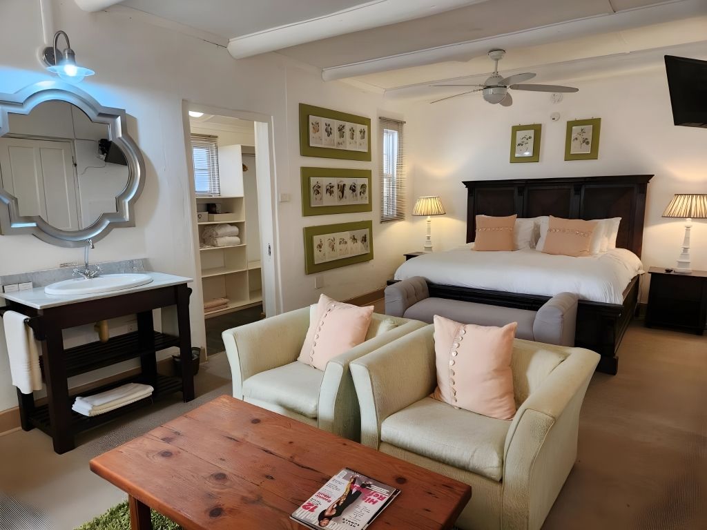 One of the guest rooms, with a sitting area and botanical prints