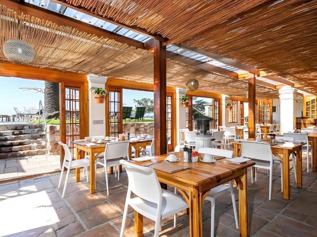 The restaurant terrace under a reed roof, open to the garden