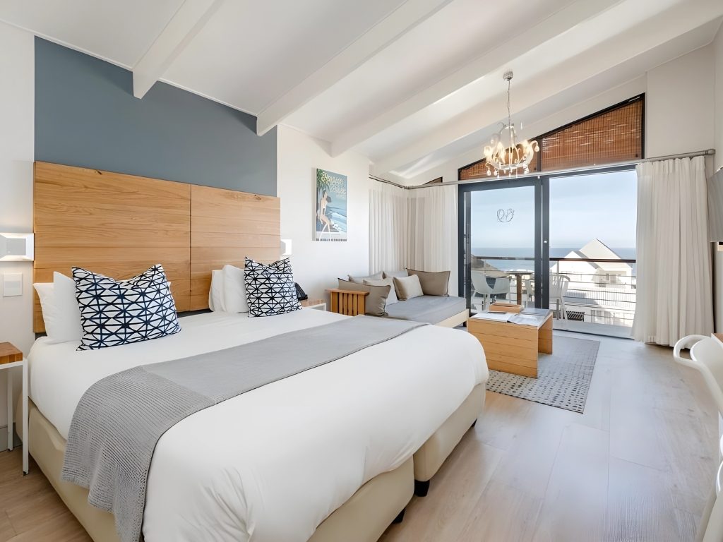 A bright room with a balcony looking out to sea
