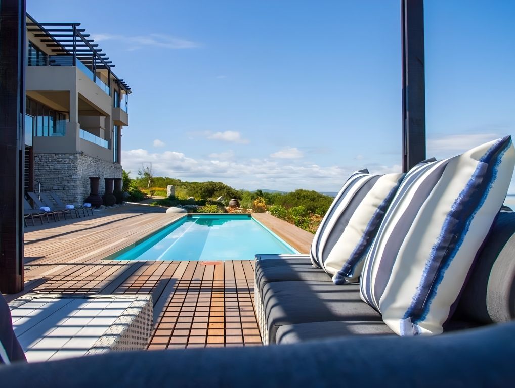 A sofa beside the pool, with the hotel behind