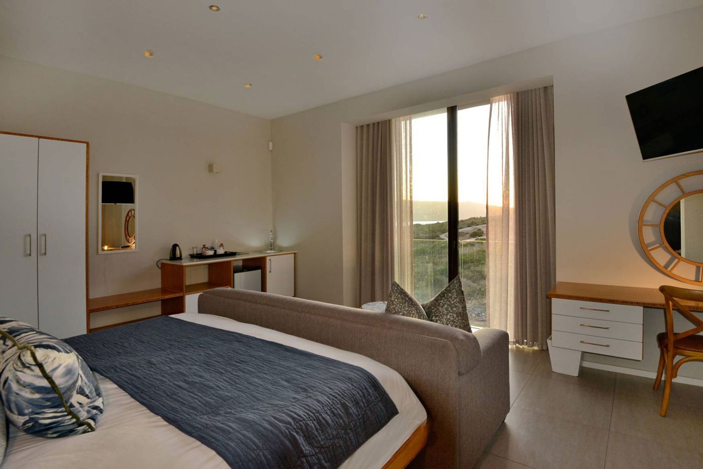 A Superior Room with glass doors towards the lagoon at sunset
