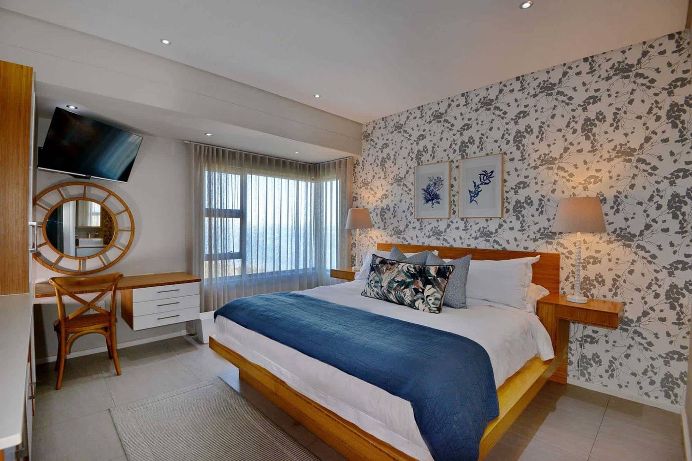 A Deluxe Room with a king bed and patterned feature wall